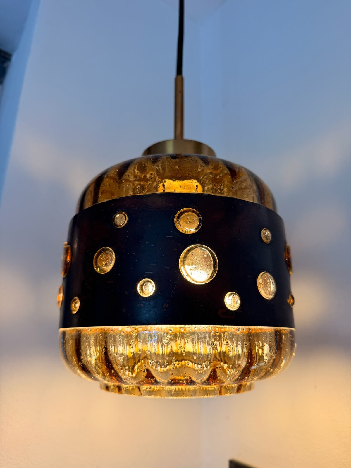 Pendelleuchte aus Bernsteinglas und Metall – Detail des beleuchteten Schirms