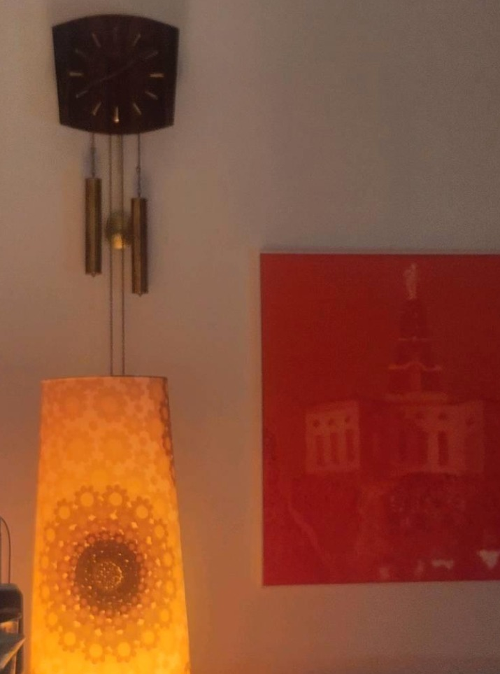 Die verkaufte Junghans-Pendeluhr bei warmem Abendlicht im Kundenwohnraum